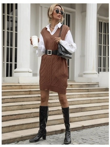 Close-up of a brown knit vest dress paired with a white collared shirt and pearl belt