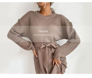 Detail of taupe waffle knit sweater dress featuring a round neck and waist tie belt