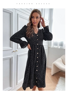 Detail view of black polka dot V-neck dress with button-front closure and ruffled cuffs