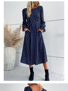 Detailed view of dark blue polka dot dress featuring long sleeves and ruffled cuffs