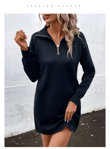 Detail of a black knit dress showing the gold circular zipper and half-zip collar design