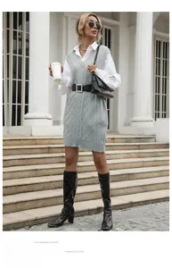 Detail of grey cable-knit sweater vest with white shirt and belted waist for autumn