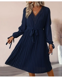 Détail de la robe plissée bleu foncé avec col en V en dentelle et poignets à cordon