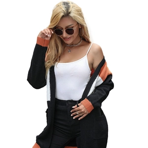 Women's long knit cardigan with black, white, and orange color block design and pockets