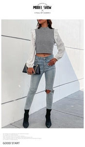 Detail van houndstooth cropped shirt met witte ruches mouwen en gescheurde jeans met taille