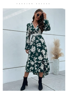 Detailed view of white lace trim and floral pattern on a dark green V-neck dress