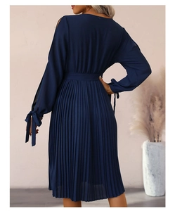 Détail d'une robe plissée bleu marine à manches longues avec poignets à nœud et ceinture