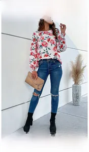 Détail d'un chemisier à fleurs rouges et d'un jean skinny bleu avec déchirures mode