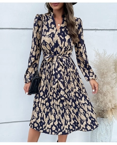 Dettaglio dell'abito con scollo a V, gonna a pieghe e laccetto in vita in stampa blu e beige