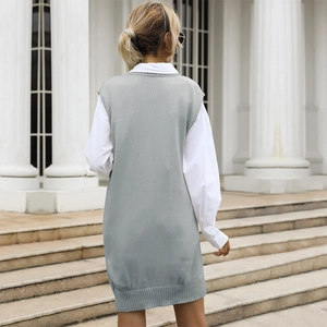 Women's blue cable knit vest dress with wide ribbed hem layered over a white shirt