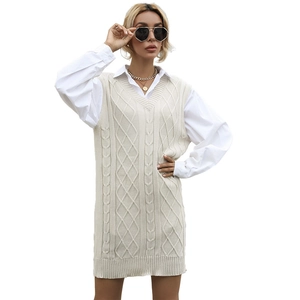 Women's cream cable-knit V-neck vest dress styled over a white long-sleeve shirt