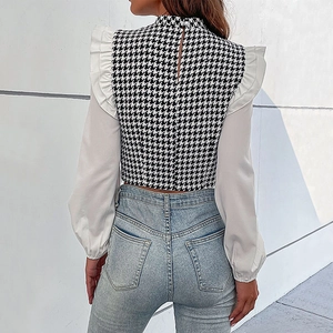 Korte dames blouse met houndstooth patroon en witte ruches op de schouders en mouwen