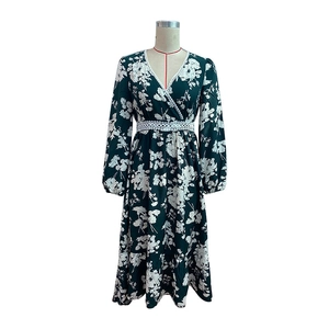 Detail of V-neckline with white lace trim and floral print on dark green dress