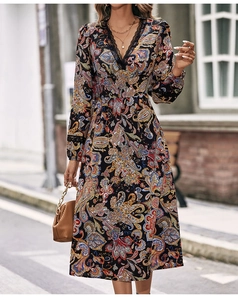 Dettaglio dello scollo a V in pizzo nero e stampa paisley su un abito midi chic