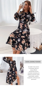 Detailed view of tiered floral maxi dress with bow-tied cuffs and round neckline