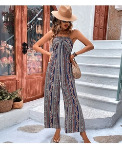 Dettaglio della tuta bohémien blu con stampa paisley, spalline sottili e nodo al collo