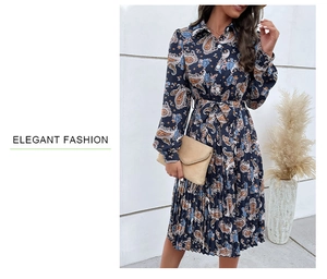 Detail of elegant paisley print maxi dress featuring long sleeves and a pleated skirt