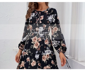 Detail of floral print dress featuring layered ruffled hem and elegant bow-tie neckline