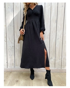 Détail d'une robe noire à manches longues avec décolleté en V et fente latérale fluide