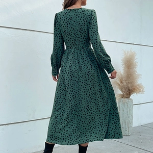 Deep green long sleeve V-neck midi dress with black polka dots and an A-line silhouette