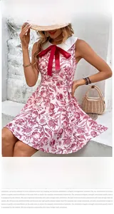 Detail of a pink A-line dress with pomegranate print, Peter Pan collar and a red bow