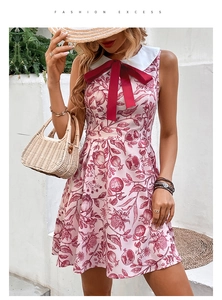 Detail of pink sleeveless dress with pomegranate print, white Peter Pan collar and red bow