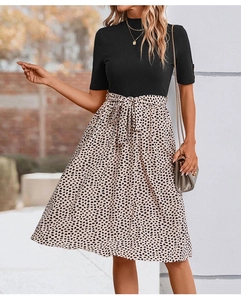 Détail d'une robe deux-pièces avec haut en tricot noir et jupe évasée à imprimé beige