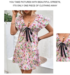 Détail d'une mini robe fleurie à col en V avec imprimé rose et nœud en ruban noir