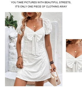Détail d'une robe d'été blanche en broderie anglaise avec col carré et grand nœud