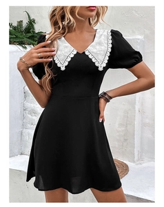 Detail of white lace embroidery collar on black puff sleeve dress with contrast V-neck
