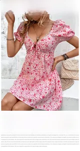 Dettaglio dello scollo a V con pizzo bianco sull'abito estivo rosa a fiori con maniche