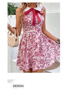 Close-up of sleeveless summer dress with pomegranate floral print and a red bow detail
