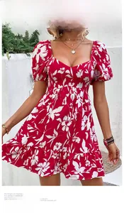 Detail of red floral mini dress with puff sleeves and heart neckline on a model