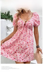 Dettaglio dello scollo a V con fiocco e maniche a sbuffo su un abito estivo a fiori rosa