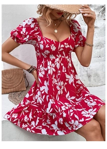 Detail of red floral summer dress with puff sleeves, heart neckline and ruffle hemline