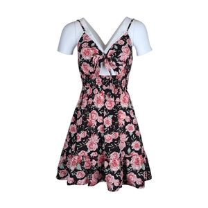 Détail d'une robe fleurie avec découpe frontale, nœud et motif de roses sur un mannequin