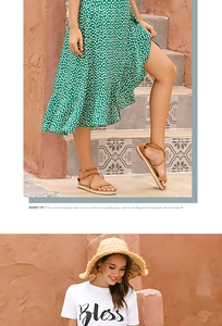 Close-up of green polka dot wrap skirt with ruffle hem and lace-up sandals
