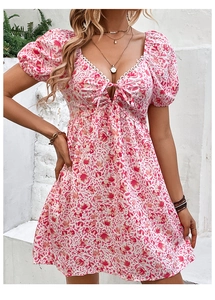 Dettaglio vestito corto a fiori con scollo quadrato in pizzo e fiocco decorativo sul petto