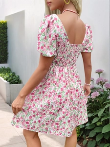 Détail du dos smocké et de l'imprimé floral de cette robe d'été rose à manches bouffantes
