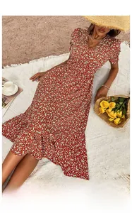 Detail of floral V-neck midi dress with puff sleeves and fishtail hem on the beach