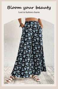 Detail of high waisted wide leg pants featuring fresh blue floral print on black fabric