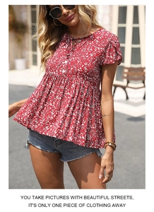 Detail of red floral blouse with drawstring neck and flutter sleeves in boho style