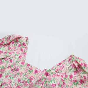 Détail du col carré et des manches bouffantes sur une robe d'été rose à fleurs