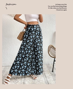 Detail of high-waist wide-leg pants featuring a vintage blue floral print on black fabric