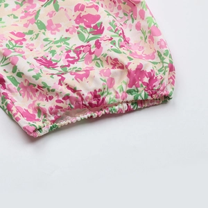 Détail de tissu floral rose avec poignets élastiques et coutures délicates