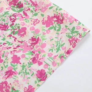 Détail de la robe à fleurs roses montrant la couture de qualité et le tissu tissé