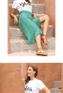 Close-up of green polka dot midi skirt with ruffled hem and white graphic t-shirt