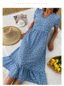 Detail of blue floral summer dress featuring V-neckline and puffed sleeves on beach