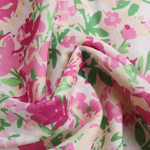 Macro détaillée du tissu en mousseline florale avec des motifs roses et verts d'été