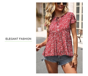 Detail of red floral puff sleeve blouse with tie neck and ruffle cuff on a sunlit street